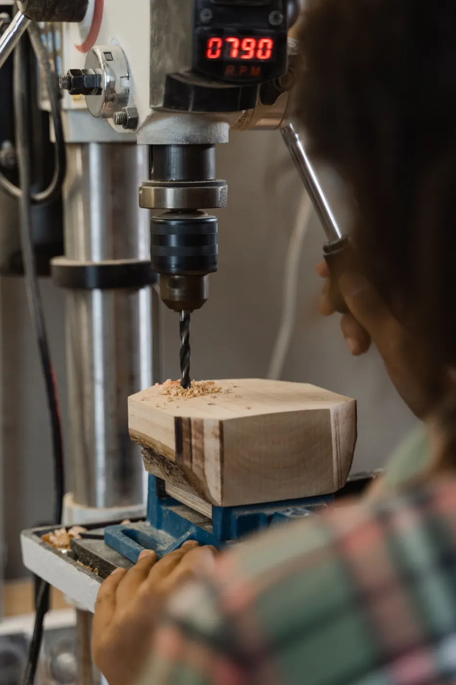 Drilling a block of wood on a drill press