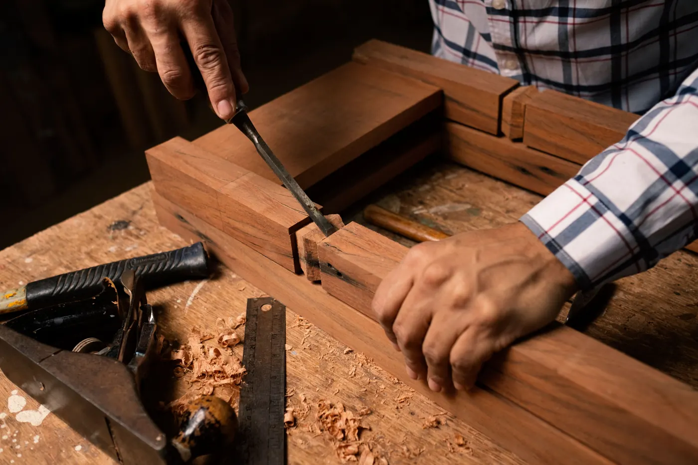 Chiselling a joint on a timber frame, with a hand plane and steel rule on the bench